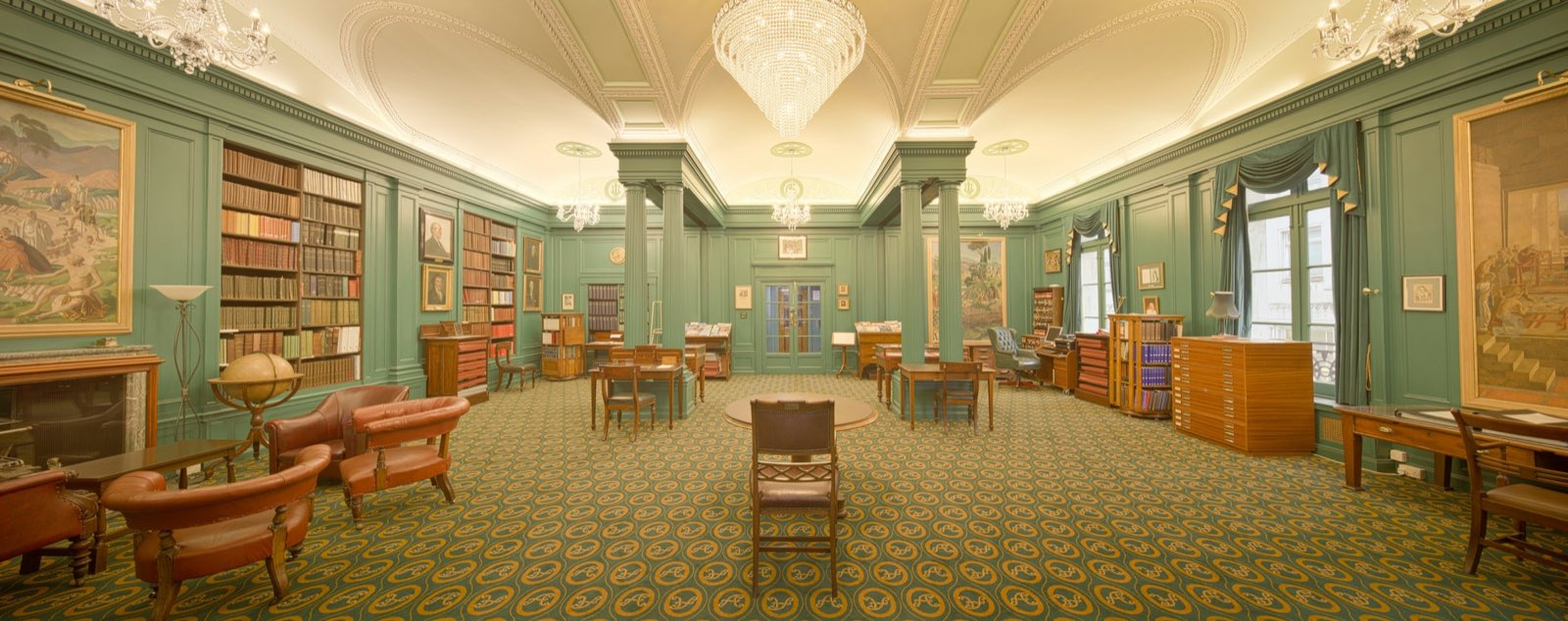 A green library room with armchairs and books
